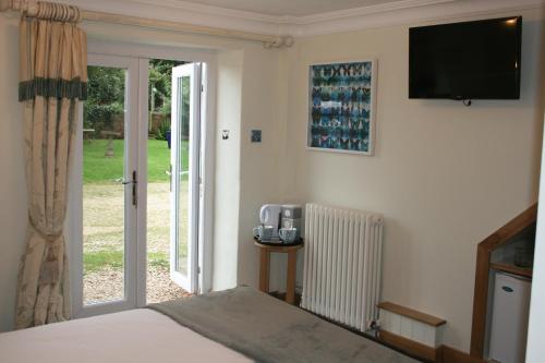 a bedroom with a bed and a television on the wall at Greenway Farm, Wembdon in Durleigh