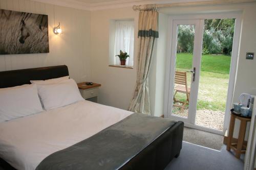 a bedroom with a bed and a sliding glass door at Greenway Farm, Wembdon in Durleigh