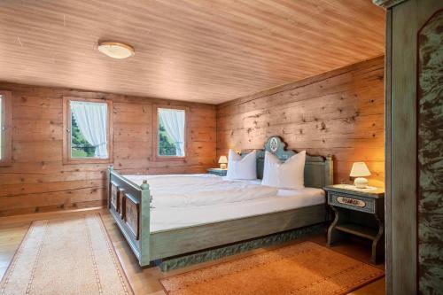 ein Schlafzimmer mit einem Bett in einem Zimmer mit Holzwänden in der Unterkunft Knusperhäuschen Höfen-hüsle in Raggal