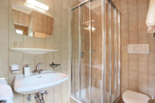 een badkamer met een wastafel en een douche bij Veltierhof in Funes