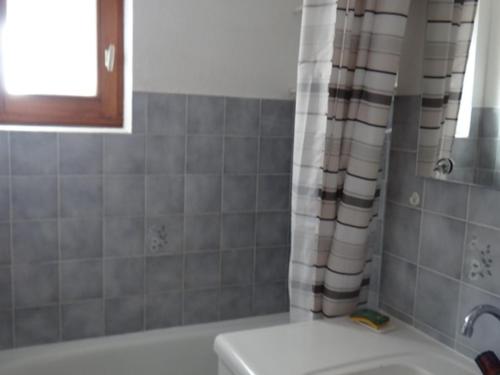 a bathroom with a tub and a shower curtain at Studio Saint-Jean-d'Aulps, 1 pièce, 5 personnes - FR-1-573-62 in Saint-Jean-d'Aulps