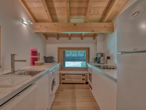 Il comprend une cuisine avec des comptoirs blancs et un plafond en bois. dans l'établissement Appartement 3 Pièces avec Cheminée et Wifi à Megève, Près des Pistes - FR-1-453-293, à Megève