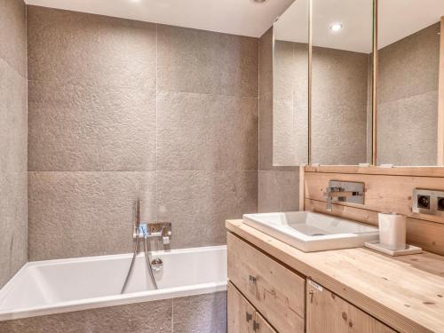 une salle de bain avec une baignoire blanche et un lavabo dans l'établissement Appartement 3 Pièces avec Cheminée et Wifi à Megève, Près des Pistes - FR-1-453-293, à Megève
