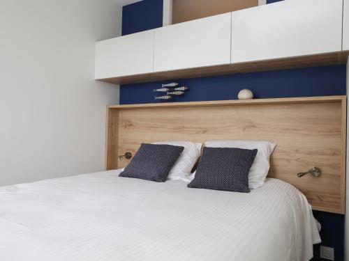 une chambre avec un lit blanc avec deux oreillers dans l'établissement La Chaume appartement coquet 4 personnes 3* wifi - FR-1-485-121, à Les Sables-dʼOlonne