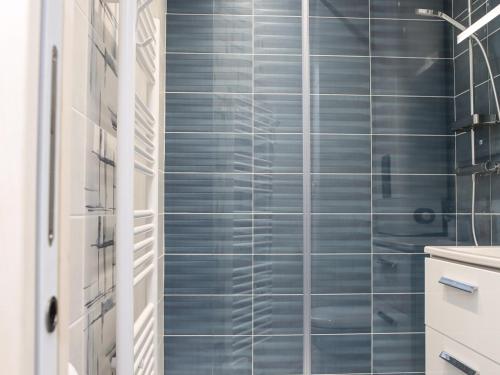 une salle de bain avec douche aux carreaux bleus dans l'établissement La Chaume appartement coquet 4 personnes 3* wifi - FR-1-485-121, à Les Sables-dʼOlonne