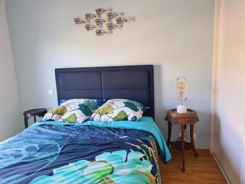 - une chambre avec un lit doté d'une couette bleue et d'une table dans l'établissement Appartement spacieux, centre ville, 2 chambres, parking, proche toutes commodités - FR-1-485-122, à Les Sables-dʼOlonne