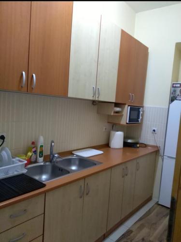 a kitchen with wooden cabinets and a sink and a refrigerator at NENSI in Prokuplje