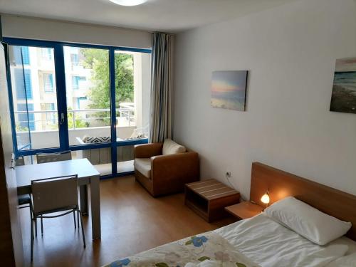 sypialnia z łóżkiem, stołem i krzesłem w obiekcie Private apartments Aparthotel Excelsior w Słonecznym Brzegu