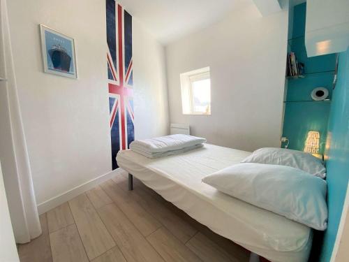 - une chambre dotée d'un lit avec un drapeau mural dans l'établissement Appartement Bénodet, 2 pièces, 2 personnes - FR-1-481-110, à Bénodet