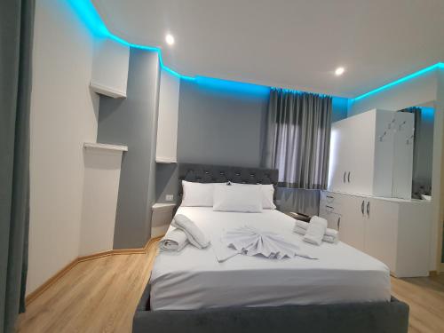 a bedroom with a white bed with blue lights at Villa Mehmeti in Sarandë