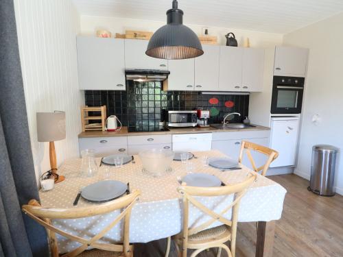 une cuisine avec une table et quatre chaises et une cuisine avec des placards blancs dans l'établissement Appartement 3 pièces cosy centre des Gets, proche télécabine, Wi-Fi - FR-1-623-311, aux Gets