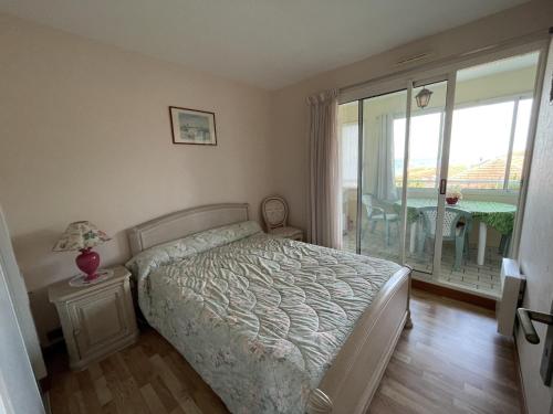 une chambre avec un lit et un balcon avec une table dans l'établissement Bel appartement T2 à deux pas des plages, avec parking et garage - FR-1-474-212, à Arcachon