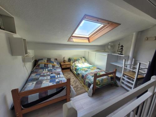 1 dormitorio pequeño con 2 camas y tragaluz en Maison Soulac-sur-Mer, 2 pièces, 5 personnes - FR-1-648-88, en Soulac-sur-Mer