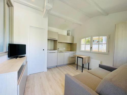 un salon blanc avec un canapé et une table dans l'établissement Studio refait à neuf, 21m², 3 pers., jardin privatif, plage et commerces à proximité, parking inclus - FR-1-433-94, à Arcachon