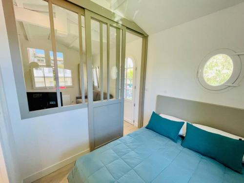 sypialnia z niebieskim łóżkiem i oknem w obiekcie Studio refait à neuf, 21m², 3 pers., jardin privatif, plage et commerces à proximité, parking inclus - FR-1-433-94 w Arcachon