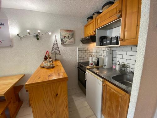 une petite cuisine avec un évier et un comptoir dans l'établissement Studio charmant avec coin montagne, accès ski, parking et WIFI à La Clusaz - FR-1-437-93, à La Clusaz