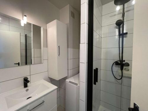 une salle de bain blanche avec une douche et un lavabo dans l'établissement Appartement rénové 2 pièces, terrasse, parking privé, proche plage et commerces - FR-1-224C-192, à Saint-Hilaire-de-Riez