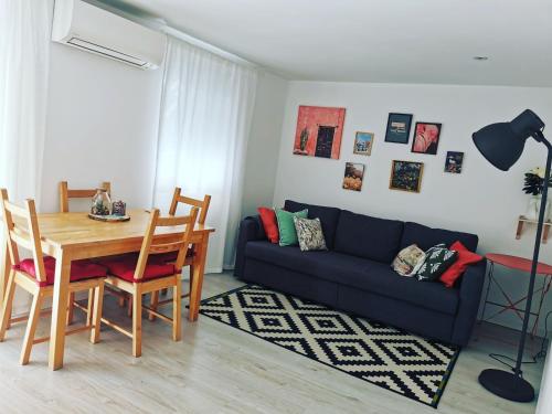 - un salon avec une table et un canapé bleu dans l'établissement Laurel No5, à Logroño