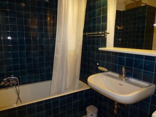 baño de azulejos azules con lavabo y bañera en Appartement Saint-Jean-d'Aulps, 1 pièce, 5 personnes - FR-1-573-89 en Saint-Jean-dʼAulps