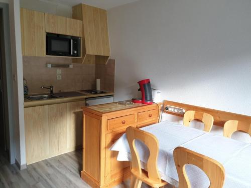 une cuisine avec une table, des chaises et un évier dans l'établissement Studio cabine 4 pers, pied des pistes, balcon, ascenseur, cave, proche télécabine - FR-1-573-91, à Saint-Jean-dʼAulps