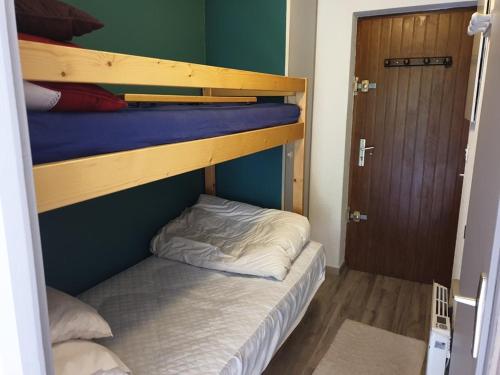 Cette petite chambre comprend 2 lits superposés et une porte. dans l'établissement Studio cabine 4 pers, pied des pistes, balcon, ascenseur, cave, proche télécabine - FR-1-573-91, à Saint-Jean-dʼAulps