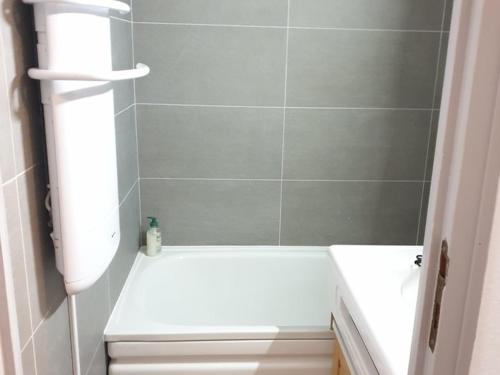 La salle de bains est pourvue d'une baignoire blanche et de toilettes. dans l'établissement Studio cabine 4 pers, pied des pistes, balcon, ascenseur, cave, proche télécabine - FR-1-573-91, à Saint-Jean-dʼAulps