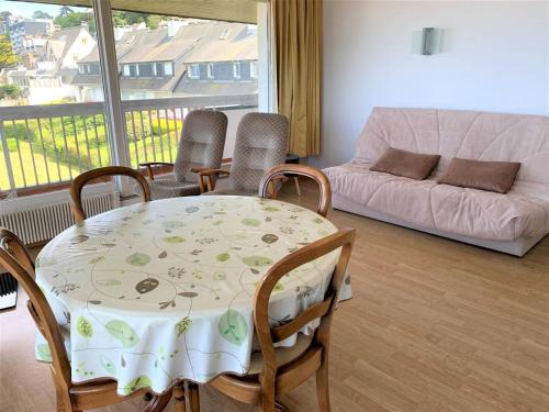 un salon avec une table, des chaises et un canapé dans l'établissement Appartement avec terrasse, parking, plage de Trestraou à Perros-Guirec - FR-1-368-350, à Perros-Guirec