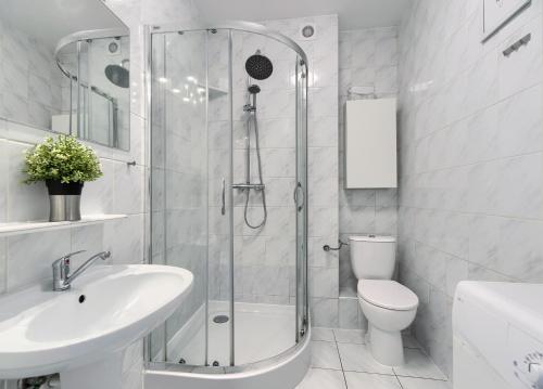 a bathroom with a shower and a sink and a toilet at Apartament Kajuta - NoclegiSopot in Sopot