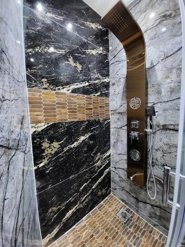 La salle de bains est pourvue d'une douche et d'un mur en pierre. dans l'établissement L'Eden sous l'olivier, à Auriol