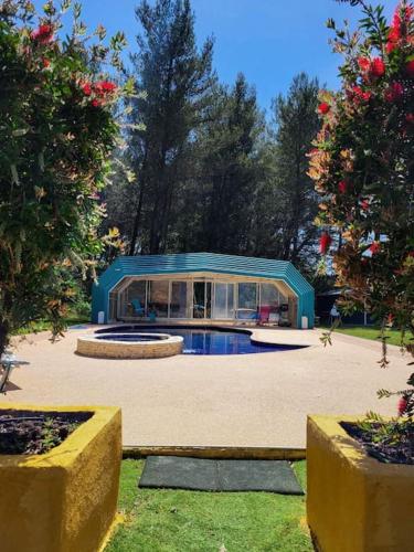 une maison avec une piscine au milieu d'une cour dans l'établissement L'Eden sous l'olivier, à Auriol