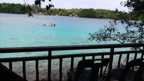 a boat in the water next to a fence at Diara bungalow in Iboih