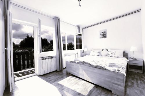 a bedroom with a large bed and a balcony at Apartment Marija Zupan in Rakovica