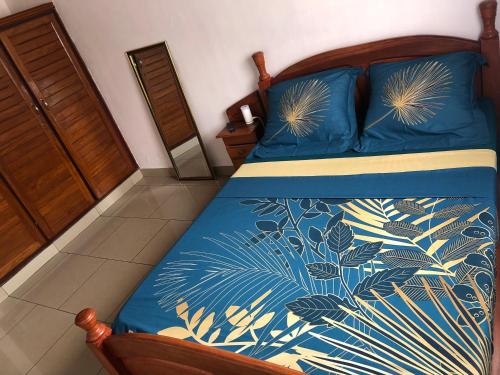 a bedroom with a bed with a blue and gold bedspread at Grand Appartement à essos mobile in Yaoundé