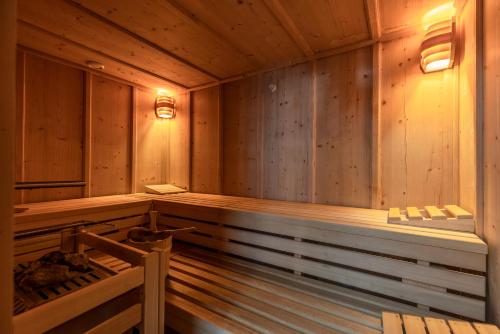 an empty wooden sauna with a bench in it at Hotel Walserberg in Warth am Arlberg