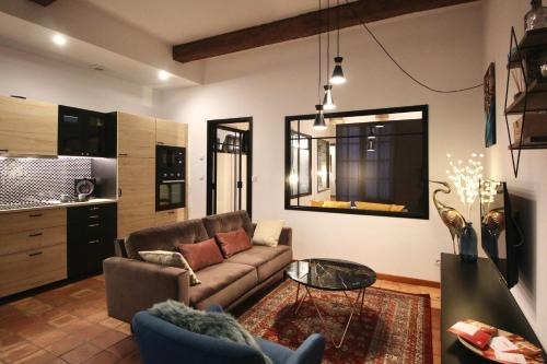 a living room with a couch and a table at Pézenas Cocoon in Pézenas