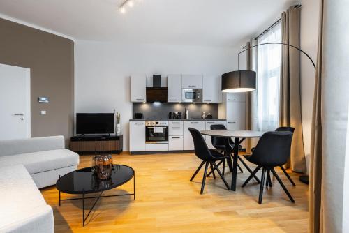 a living room with a table and chairs and a kitchen at Trendy apt with - smart TV, coffee machine in Meidling in Vienna