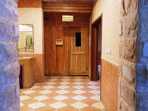 a hallway with a wooden door and a tiled floor at Shafa Abha Hotel in Abha