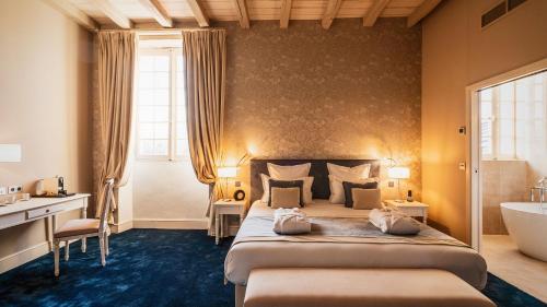 a hotel room with a bed and a bath tub at Abbaye De Villeneuve in Les Sorinières