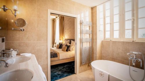 a bathroom with a bath tub and a bed at Abbaye De Villeneuve in Les Sorinières