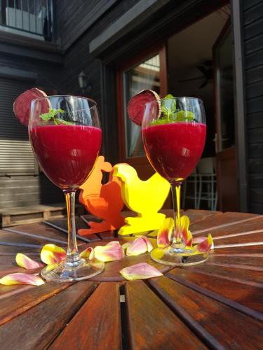 two wine glasses sitting on top of a wooden table at Pensjonat Willa w Parku in Polanica-Zdrój