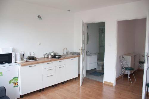 eine Küche mit weißen Schränken und einem Waschbecken in der Unterkunft APARTAMENT i pokoje Aura Dom Wczasowy in Darłówko