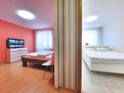 a bedroom with two beds and a television in it at Червоне і біле Мережа квартир Alex Apartments Документи для відряджень Безконтактне заселення 24-7 in Poltava