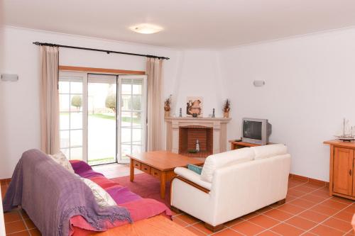 a living room with a white couch and a table at 19 Aldeia Viriato in Casal da Lagoa Seca