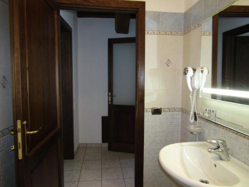 a bathroom with a sink and a phone on the wall at Agriturismo Colle della Pace in Bevagna