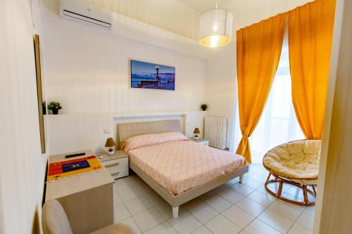 um quarto com uma cama, uma secretária e uma cadeira em Antonella home b&b em Bari