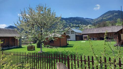 un patio con una valla y un árbol y casas en Садиба Файні Карпати en Krasnik