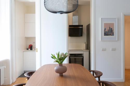 jadalnia ze stołem i wazonem w obiekcie Elegant and bright apartment, Milano Gerusalemme w Mediolanie