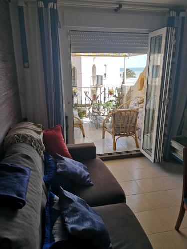 a living room with a couch and a sliding glass door at En Marina D'Or primera linea real in Oropesa del Mar