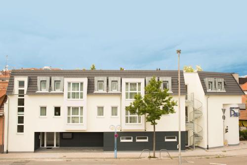 un bâtiment blanc avec un arbre devant lui dans l'établissement Best Western Plus Palatin Kongresshotel, à Wiesloch