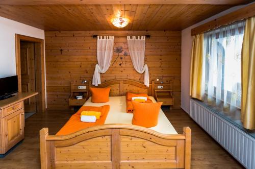 a bedroom with a large bed with orange pillows at Haus Alpenblick in Ehrwald